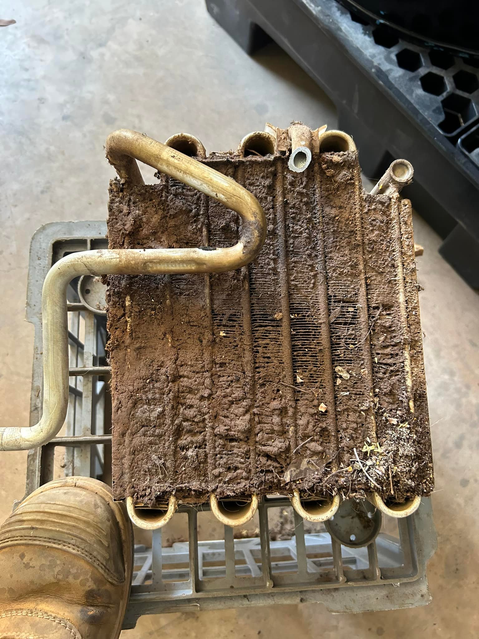 A vehicle air-conditioning core removed from a car and packed solid with red Kimberley dirt and grass seed
