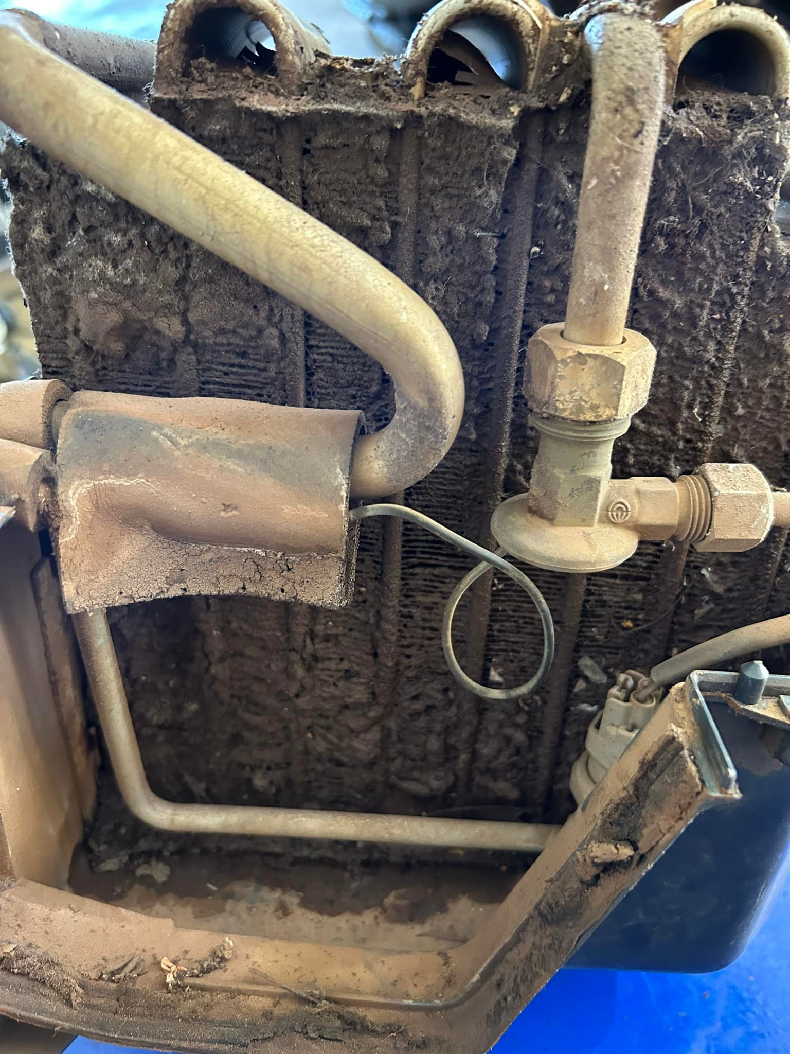 A blocked air-conditioning core showing the tap fitting and caked face