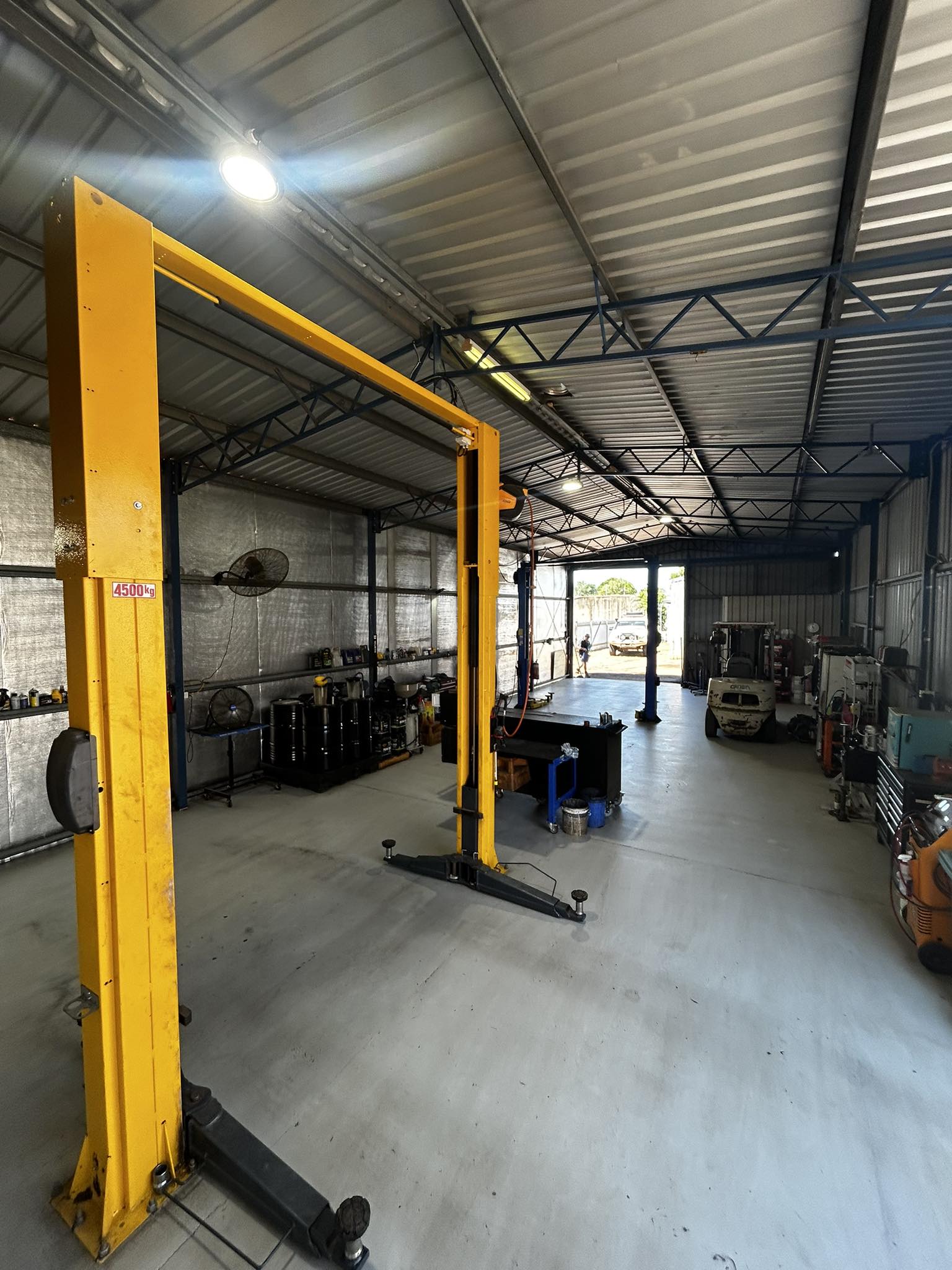 A two post hoist and workbench inside the D&H Mechanical workshop
